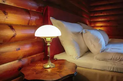 a lamp on a table next to a bed with pillows at Jervell 1 Bnb in Ålesund