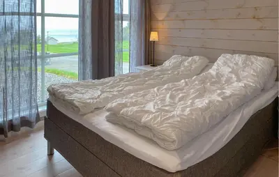 a large bed in a room with a window at 4 Bedroom Nice Home In Hildre in Hildre