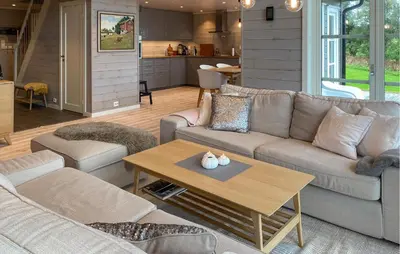 a living room with a couch and a table at 4 Bedroom Nice Home In Hildre in Hildre