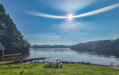 a picnic table sitting on the grass next to a lake at 5 Bedroom Cozy Home In Hebnes in Hebnes
