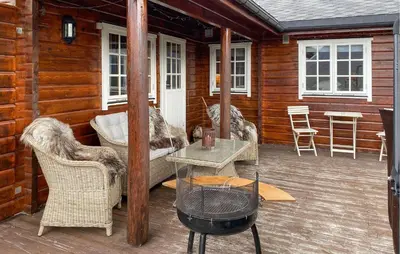 a porch of a cabin with chairs and a table at Lovely Home In Bjorli With Wifi in Bjorli
