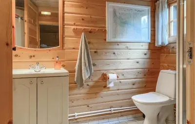 a bathroom with wooden walls and a toilet and a sink at Lovely Home In Bjorli With Wifi in Bjorli