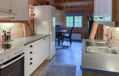 a kitchen with white cabinets and a sink and a table at Lovely Home In Bjorli With Wifi in Bjorli