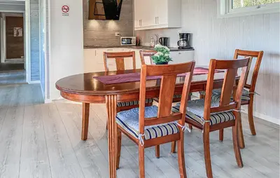 a wooden dining room table with chairs and a kitchen at 3 Bedroom Beautiful Home In Torvikbukt in Torvikbukt