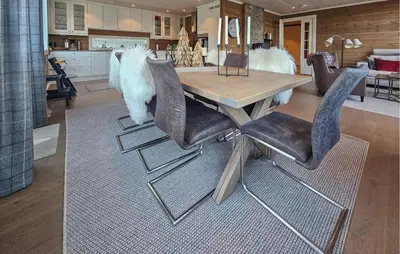 a dining room table with black chairs and a kitchen at 5 Bedroom Nice Home In Edland in Vågsli