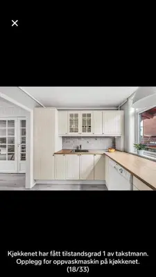a kitchen with white cabinets and a counter top at Koselig rekkehus med tre soverom in Trondheim
