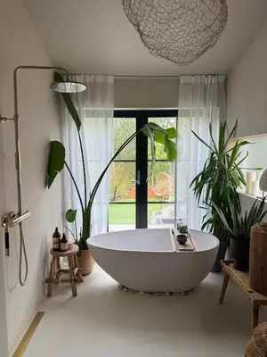 a bath tub in a bathroom with plants at Vakreste plass og beliggenhet! in Trondheim