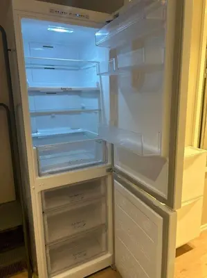 an empty refrigerator with its door open in a kitchen at Koselig studioleilighet i sentrum in Trondheim