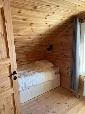 a bedroom with a bed in a wooden room at Delikat tømmerhytte på Blefjell in Flesberg