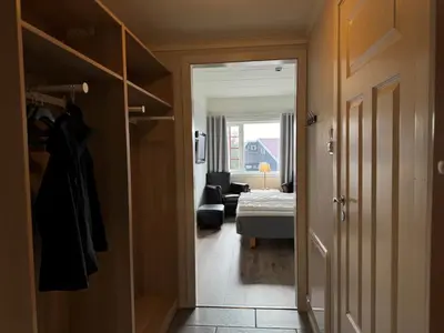 a hallway leading to a bedroom with a bed at Bitihorn hotellfølelse i sentrum in Beitostøl