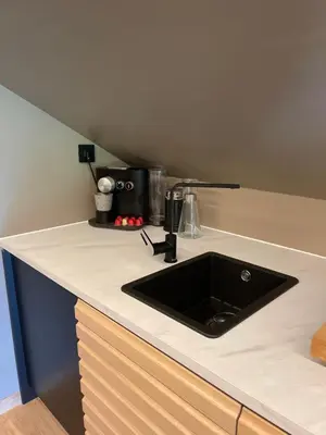 a kitchen counter with a black sink in it at Leilighet på to plan nyoppusset sentralt på Tyholt Trondheim in Trondheim