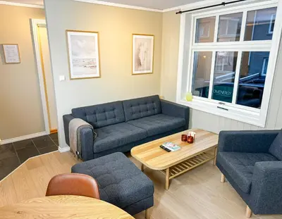 a living room with two couches and a table at Sentral leilighet med parkering og peis in Bergen