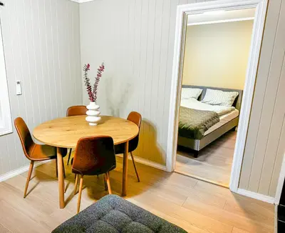 a dining room with a table and a mirror at Sentral leilighet med parkering og peis in Bergen
