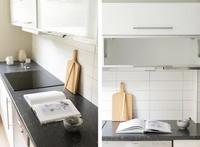 a kitchen with white appliances and an open book on a counter at Sentral leilighet med parkering og peis in Bergen