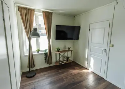 a room with a door and a tv and a window at Stylish place in the heart of Bergen in Bergen