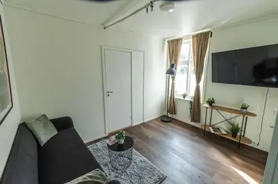 a living room with a couch and a flat screen tv at Stylish place in the heart of Bergen in Bergen