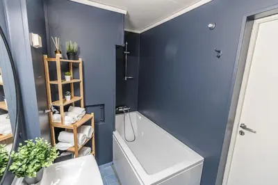 a bathroom with a white tub and a blue wall at Stylish place in the heart of Bergen in Bergen