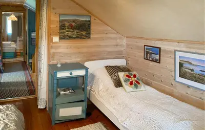 a small bedroom with a bed and a blue table at Nice Home In Farstad With Wifi in Farstad