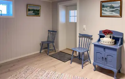 a room with two chairs and a blue cabinet with a vase on it at 3 Bedroom Stunning Home In Fiksdal in Fiksdal