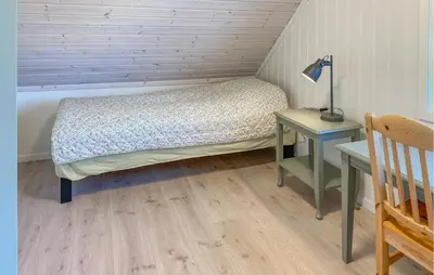 a small bedroom with a bed and a table at 3 Bedroom Stunning Home In Fiksdal in Fiksdal