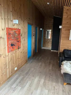 a living room with a couch and wooden walls at Moderne hytte Sjusjøen in Sjusjøen