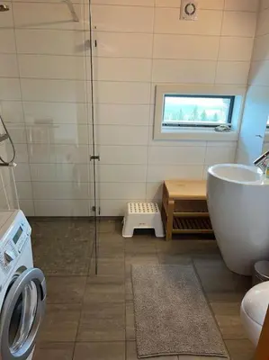 a bathroom with a shower and a tub and a sink at Moderne hytte Sjusjøen in Sjusjøen