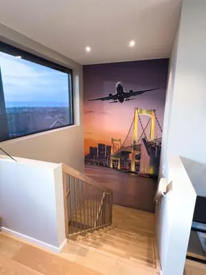 a staircase with a mural of an airplane flying over a city at Ski VM 2025 Eksklusivt hus in Trondheim