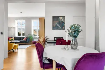 a living room with a table and purple chairs at Sentral og stilfull leilighet in Bergen