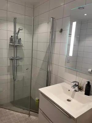 a bathroom with a shower and a sink and a mirror at Heimdal Sentrum in Heimdal