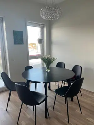 a dining room with a black table and chairs at Heimdal Sentrum in Heimdal