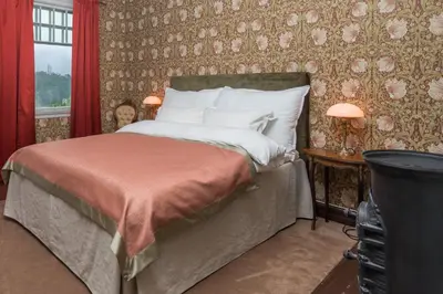 a bedroom with a bed with a red wall at Jervell 3 Bnb in Ålesund
