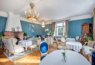 a room with tables and chairs and a fireplace at Jervell 3 Bnb in Ålesund