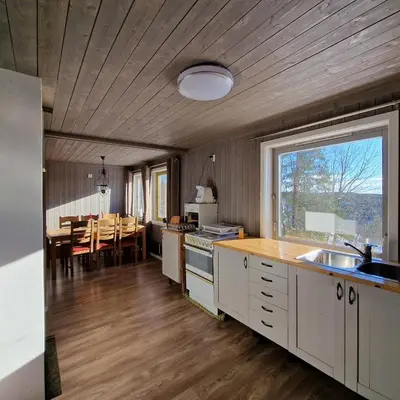 a kitchen and dining room with a table and a window at Captivating 6-Bed Cottage in Lismarka in Haugen
