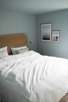 a large white bed in a bedroom with two pictures on the wall at Måløy Fjordbuer moderne og luksuriøse med havutsikt in Måløy