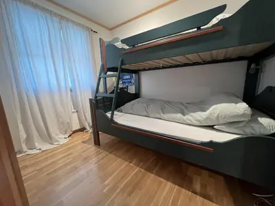 a bedroom with two bunk beds and a wooden floor at Stylish And Spacious Apartment In The Heart Of Beitostølen in Beitostøl