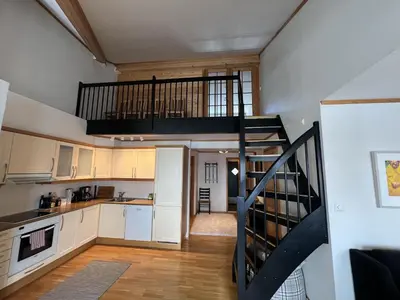a kitchen with a staircase leading up to a loft at Stylish And Spacious Apartment In The Heart Of Beitostølen in Beitostøl