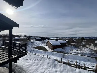 a snow covered yard with a barn in the distance at Stylish And Spacious Apartment In The Heart Of Beitostølen in Beitostøl