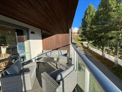 a balcony with wicker chairs and a table on a porch at Modern apartment in the heart of Geilo center in Geilo
