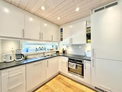 a kitchen with white cabinets and a refrigerator at Modern apartment in the heart of Geilo center in Geilo