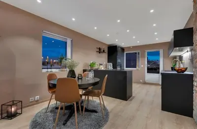 a kitchen and dining room with a table and chairs at Upgraded 3 bedroom apartment, close to WC-25 in Trondheim