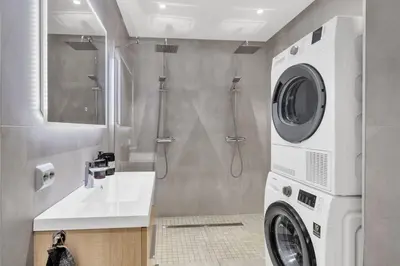 a bathroom with a shower and a washing machine at Upgraded 3 bedroom apartment, close to WC-25 in Trondheim