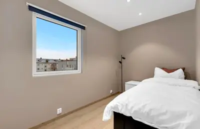 a bedroom with a white bed and a window at Upgraded 3 bedroom apartment, close to WC-25 in Trondheim