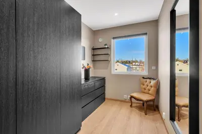 a bedroom with a dresser and a window and a chair at Upgraded 3 bedroom apartment, close to WC-25 in Trondheim