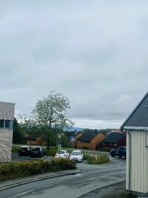 a street with cars parked in a parking lot at Trondheim- free parking in Høiset
