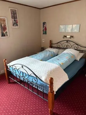 a bedroom with a bed with a blue comforter at Cozy apartment near city center and nature in Kristiansund
