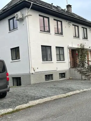 a white house with a car parked in front of it at Bergen peaceful loft in Bergen