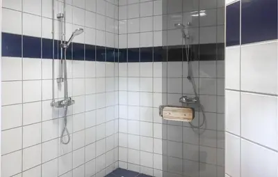 a shower in a white tiled bathroom at Lovely Apartment In Bjorli With Sauna in Bjorli