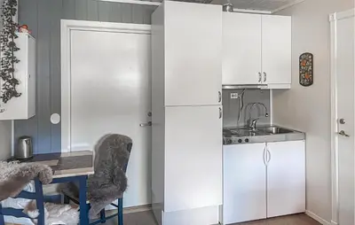 a kitchen with white cabinets and a table and a sink at Lovely Apartment In Bjorli With Sauna in Bjorli