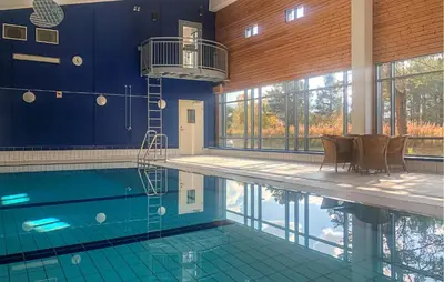 a swimming pool in a building with chairs in it at Lovely Apartment In Bjorli With Sauna in Bjorli