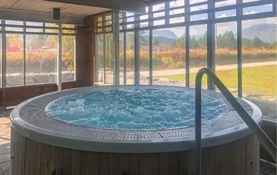 a hot tub in a room with a large window at Lovely Apartment In Bjorli With Sauna in Bjorli